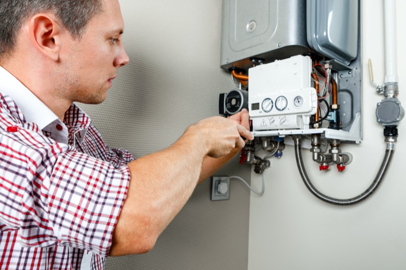 Plumber servicing residential heating equipment