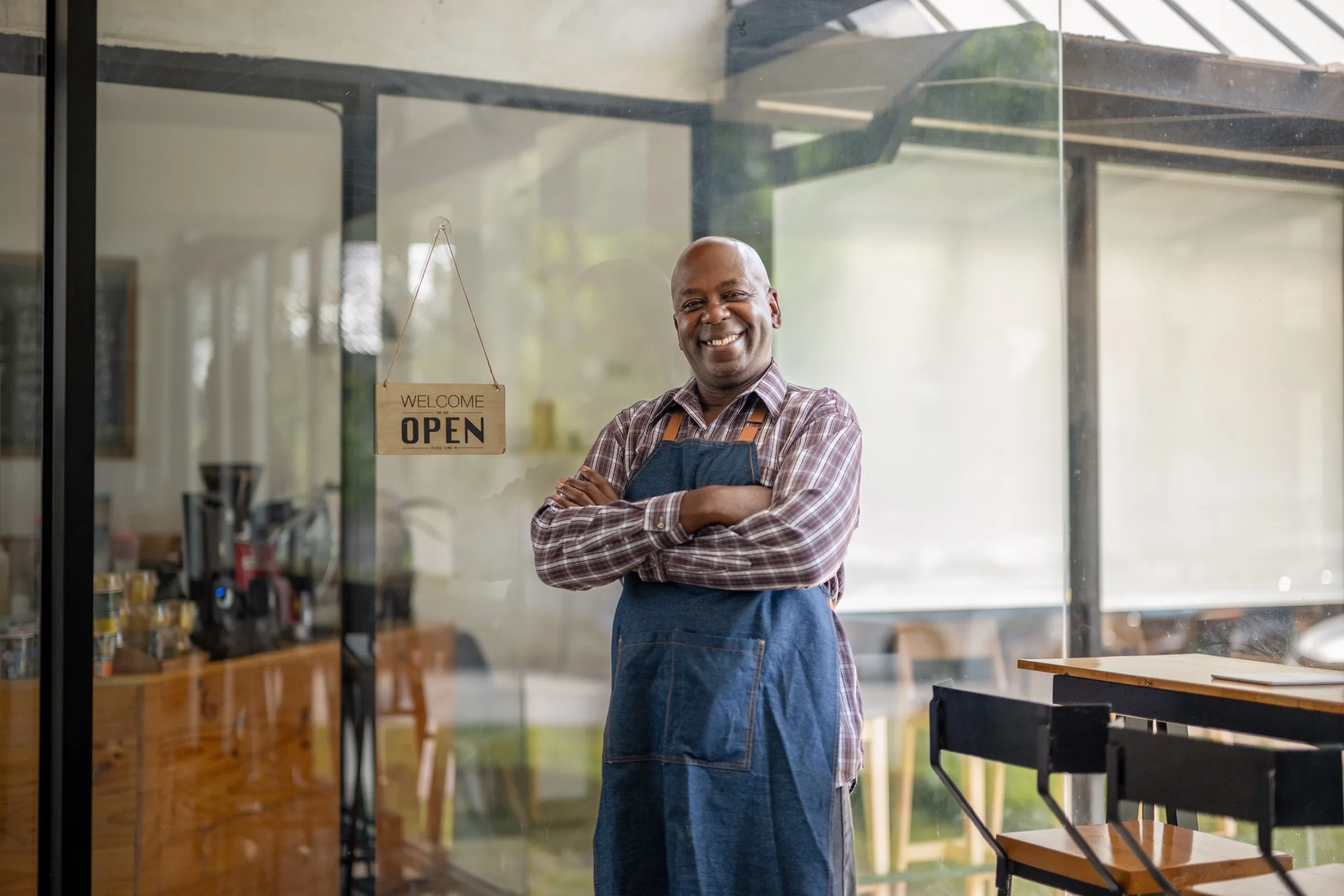 A proud small-business owner standing in their open shop